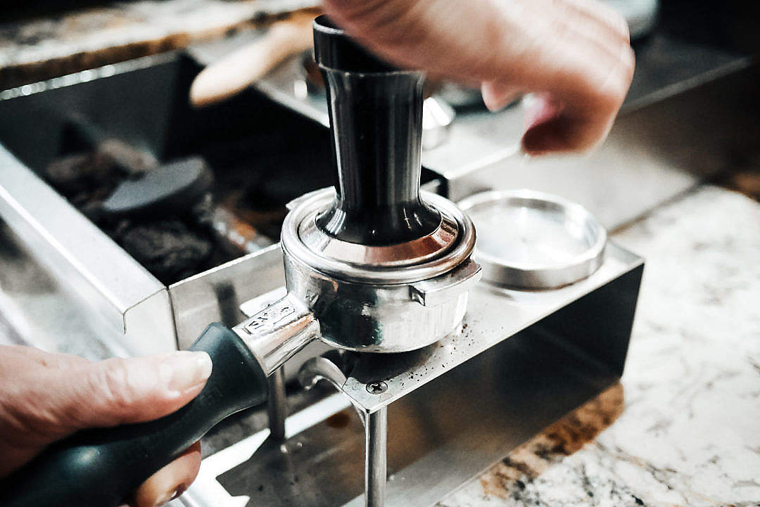 Download Barista is Pressing Ground Coffee in the Cafe Shop FREE Stock Photo