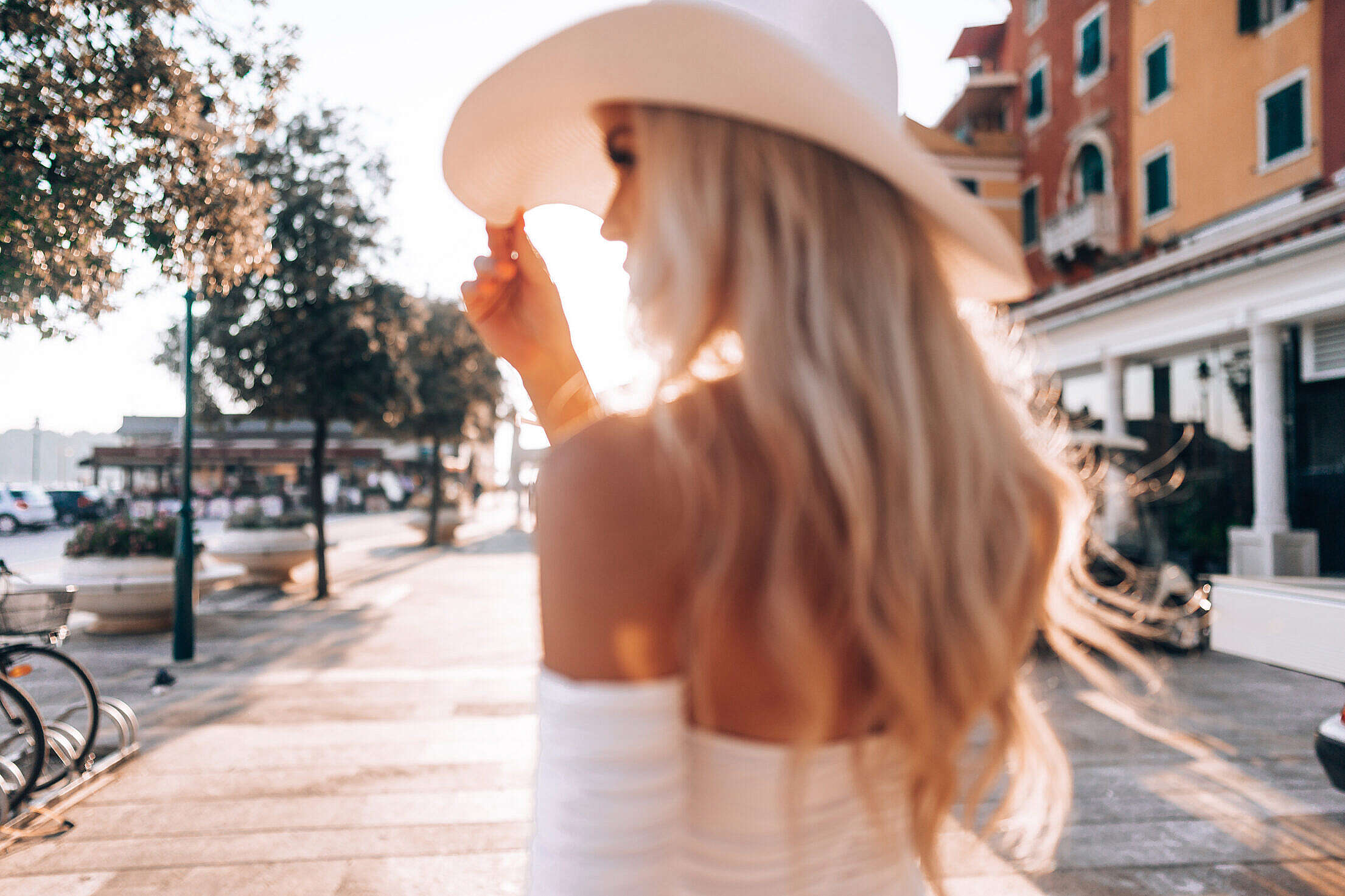 Beautiful Blonde Woman in White Straw Hat Walking Around Rovinj, Croatia Free Stock Photo