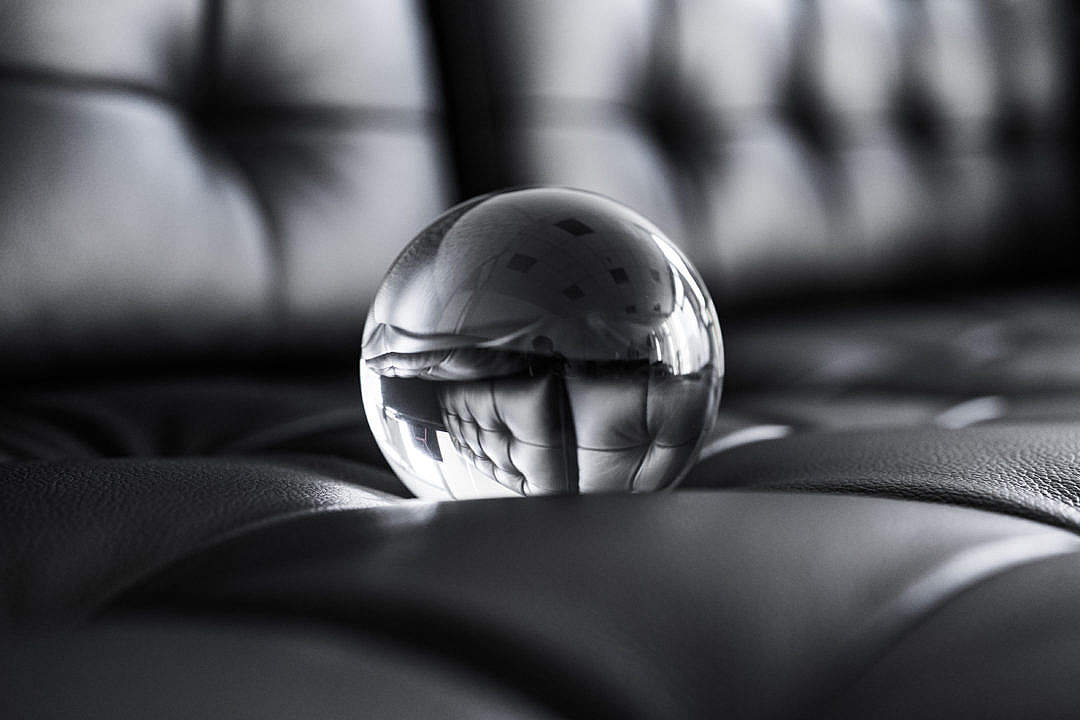 Big Glass Crystal Ball on Black Leather Sofa