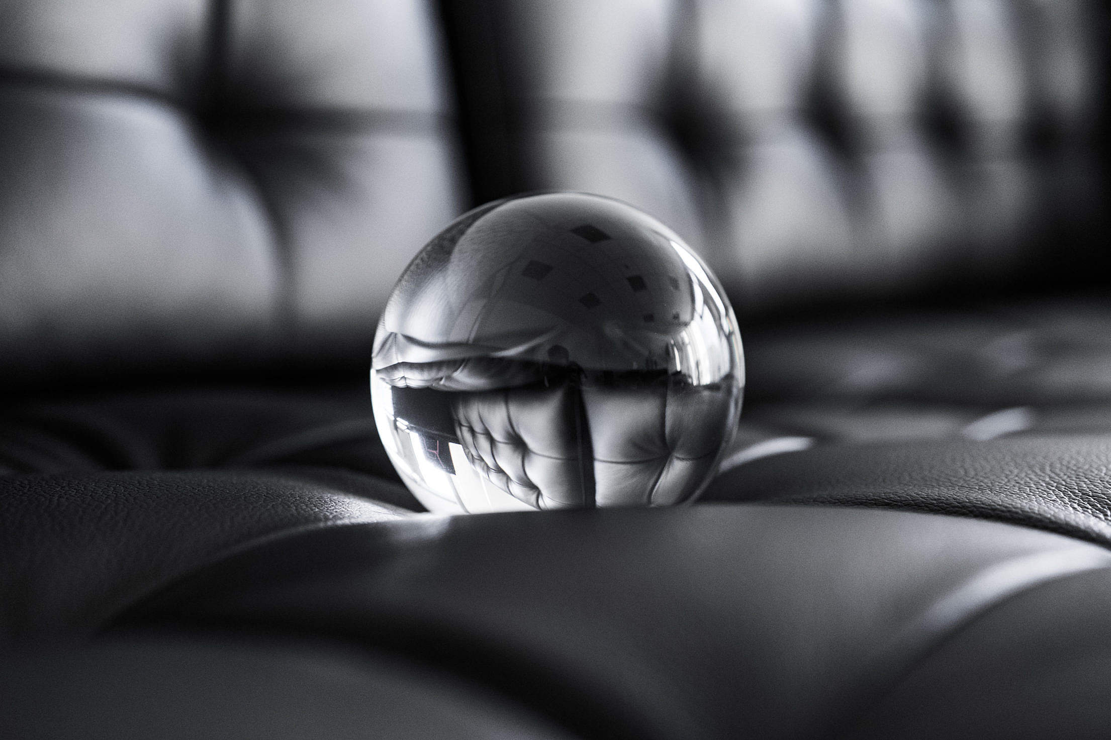 Big Glass Crystal Ball on Black Leather Sofa Free Stock Photo