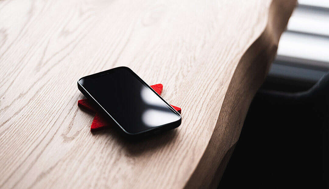 Download Black Smartphone Lying on a Wooden Table FREE Stock Photo