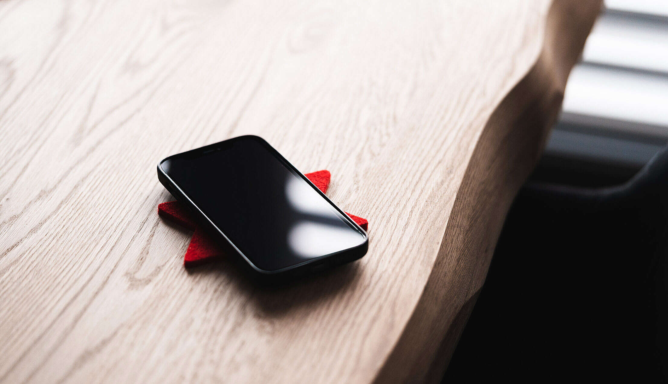 Black Smartphone Lying on a Wooden Table Free Stock Photo