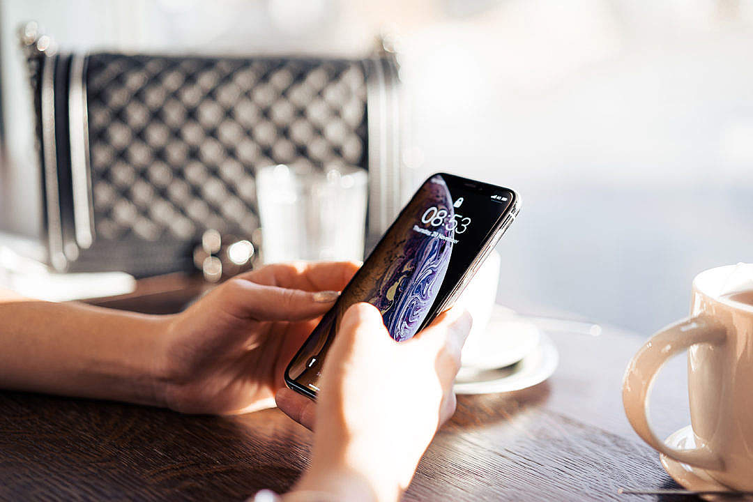 Business Woman Using Her iPhone in a City Café