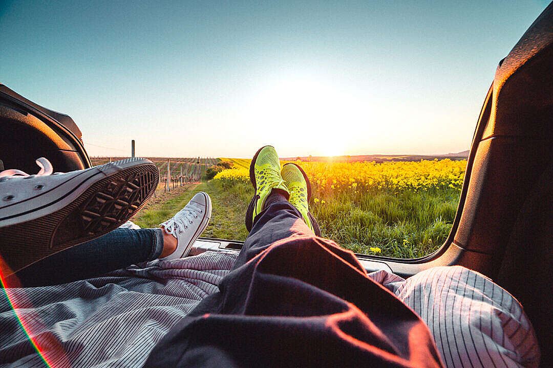 Download Couple Enjoying Sunset from the Car Trunk FREE Stock Photo