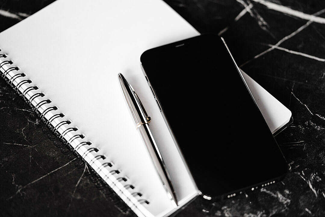 Download Diary, Silver Pen and Smartphone on Black Marble Table FREE Stock Photo