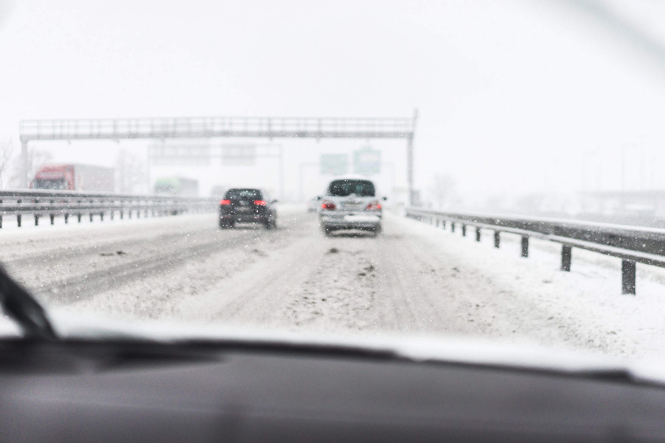 Driving in a Dangerous Snowy Weather on a Highway (focus on snowflakes) Free Stock Photo