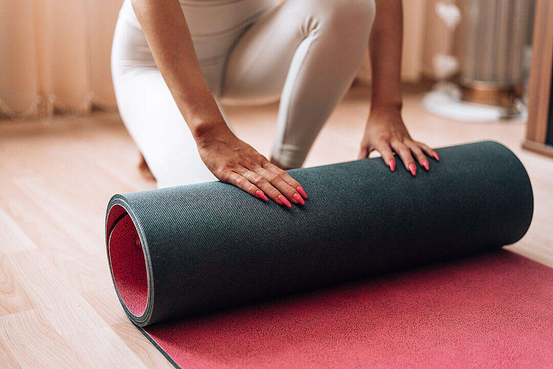 Download Fit Woman Rolls Her Exercise Yoga Mat at Home FREE Stock Photo