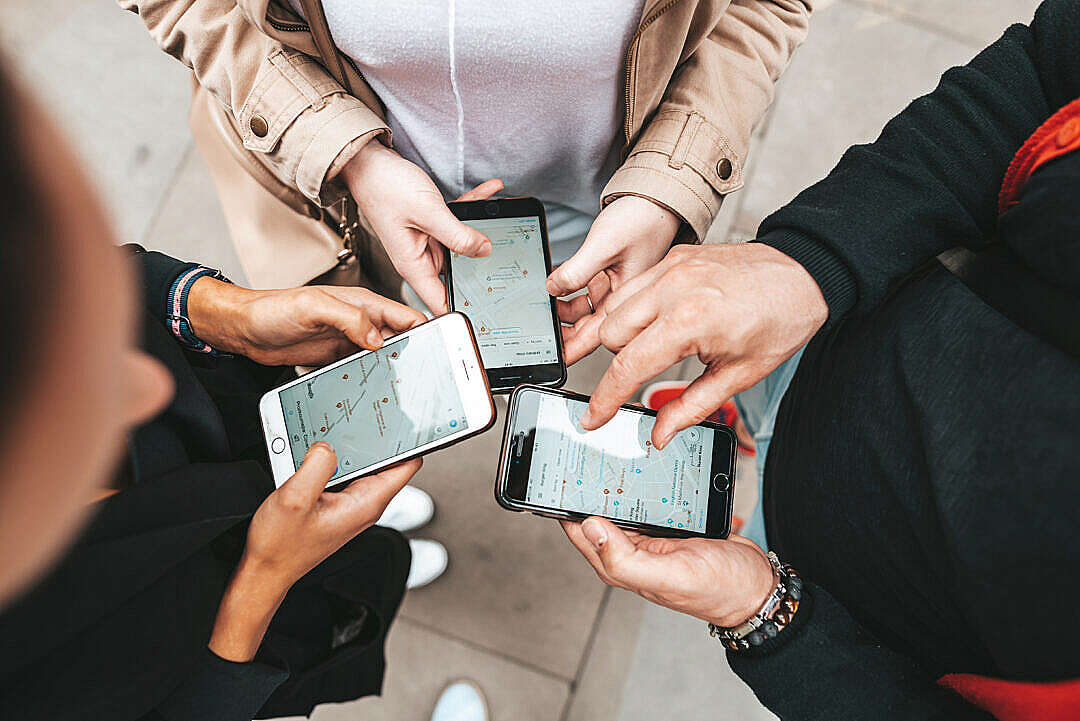 Friends Using Their Smartphones to Find The Right Way