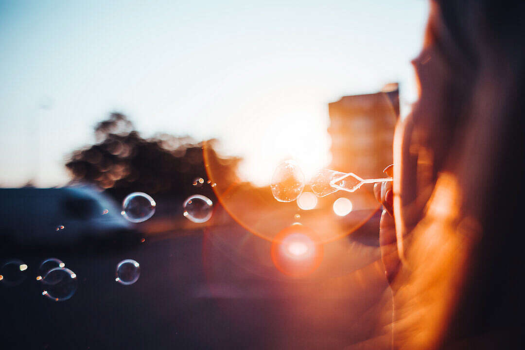 Girl Blowing Bubbles in the Sunset Evening