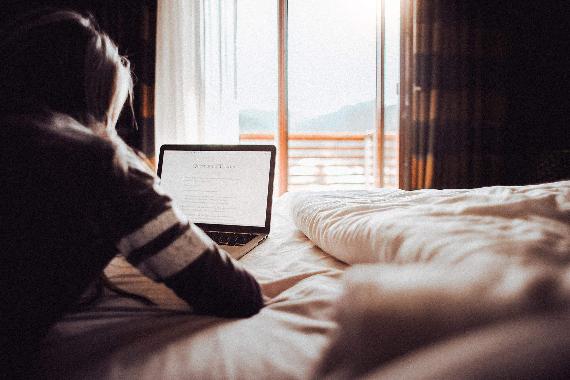 Girl Reading a Blog in a Bedroom Free Stock Photo