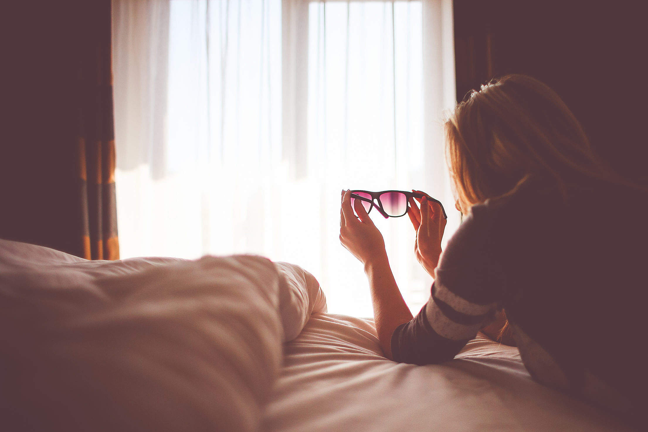 Girl with Sunglasses in a Bed Free Stock Photo