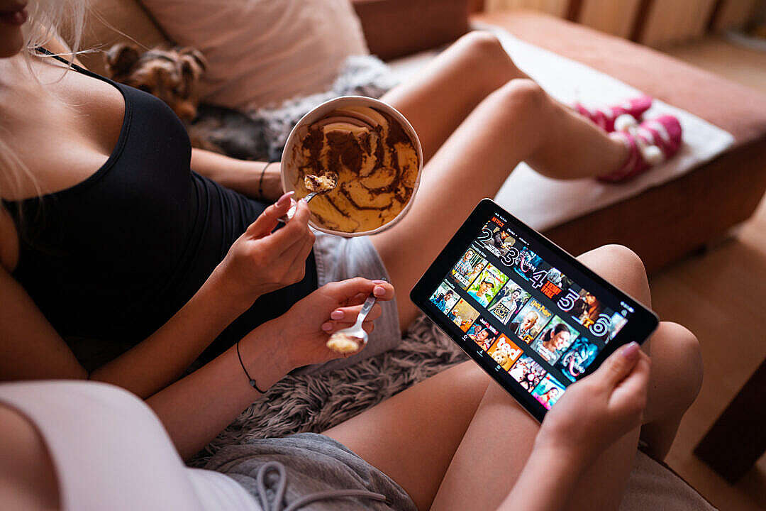 Download Girls Eating Ice Cream and Watching Netflix on a Tablet FREE Stock Photo