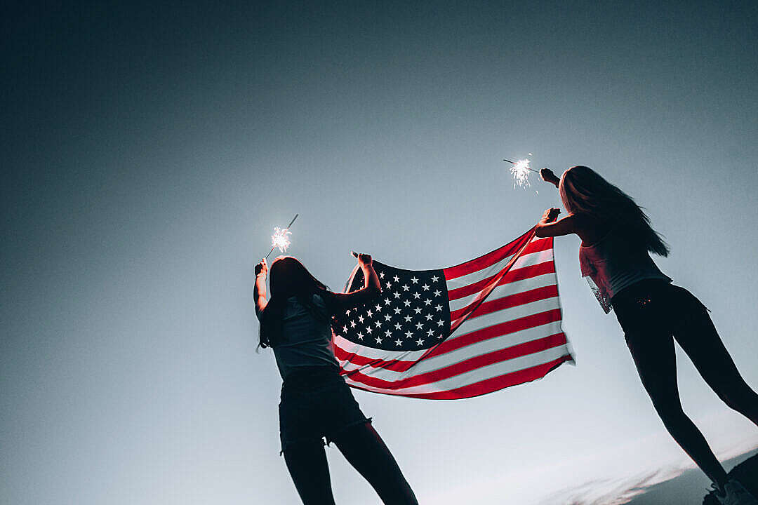 Girls Holding American Flag and Sparklers