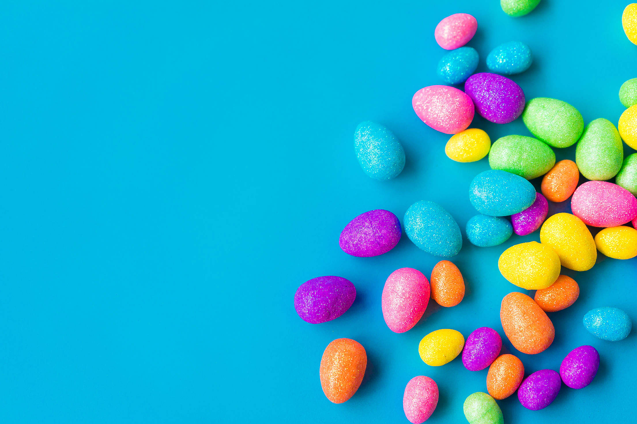 Glittering Easter Eggs on Blue Background with Space for Text Free Stock Photo