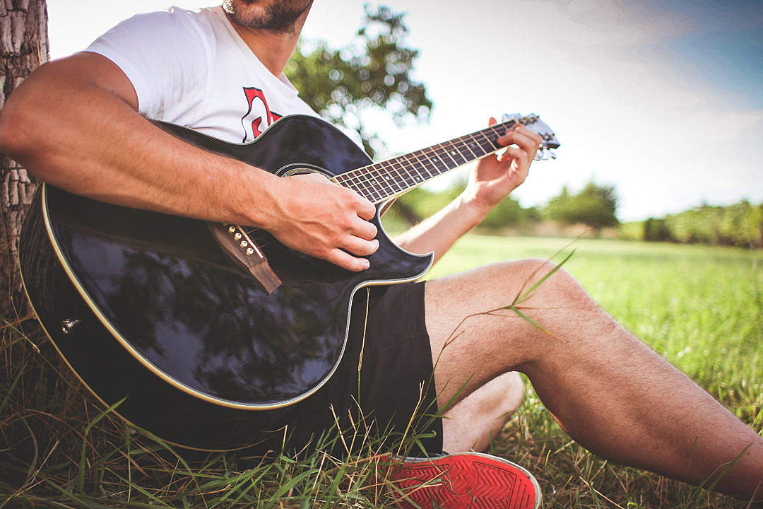 Download Guy Playing Acoustic Guitar in Nature FREE Stock Photo