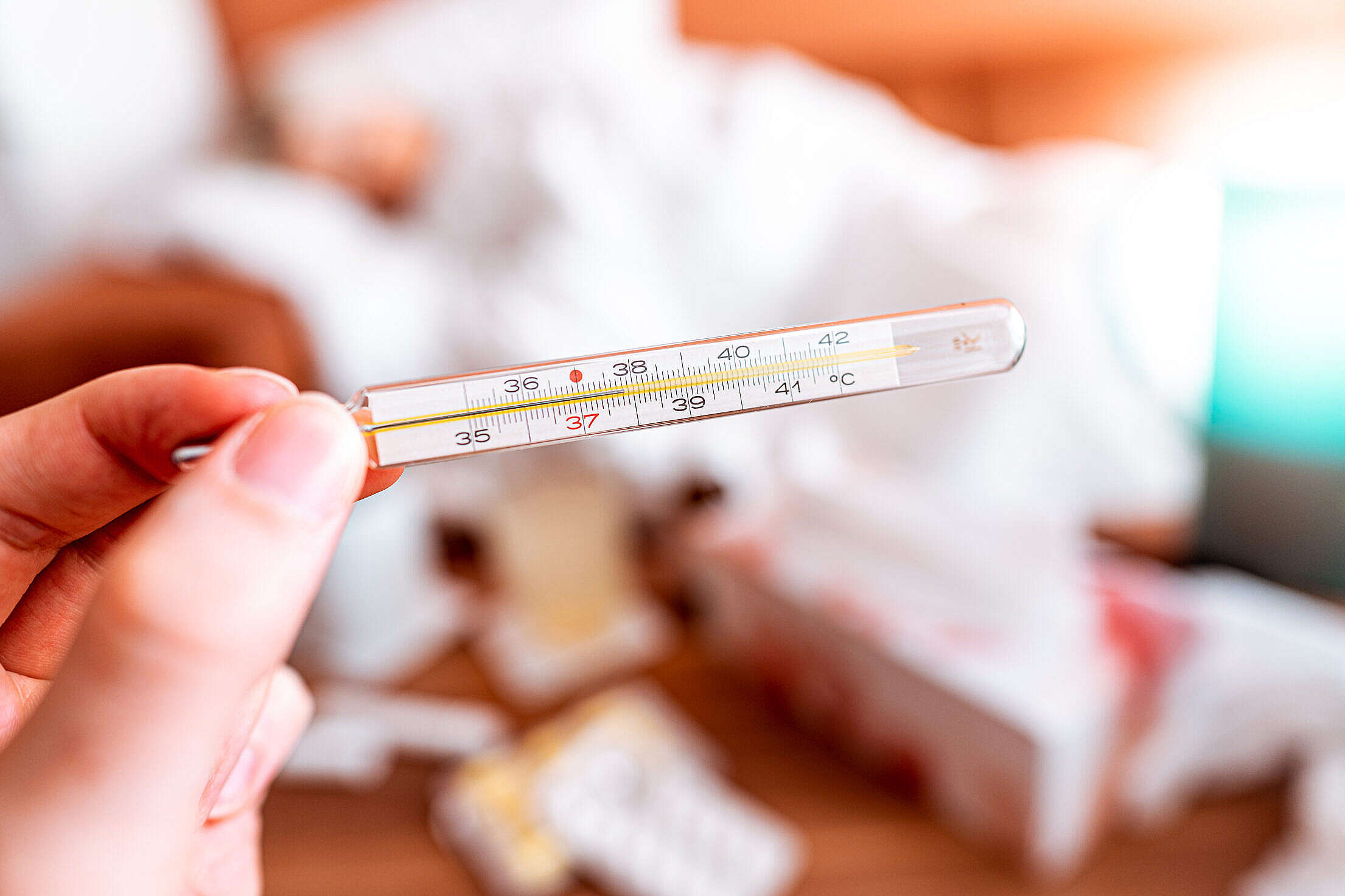 Hand Holding a Mercury Thermometer Free Stock Photo