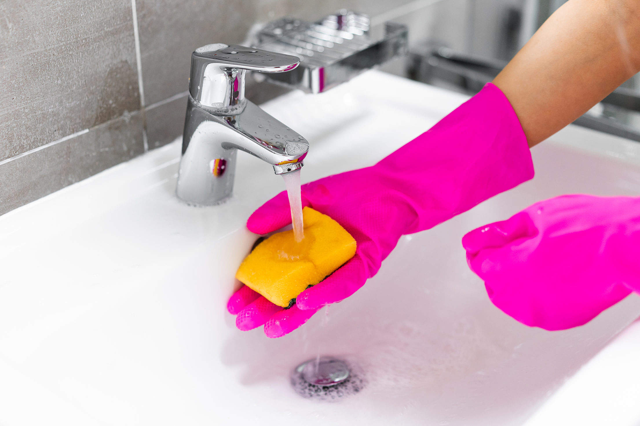 Hands in Pink Gloves Washing a Washbasin with a Sponge Free Stock Photo
