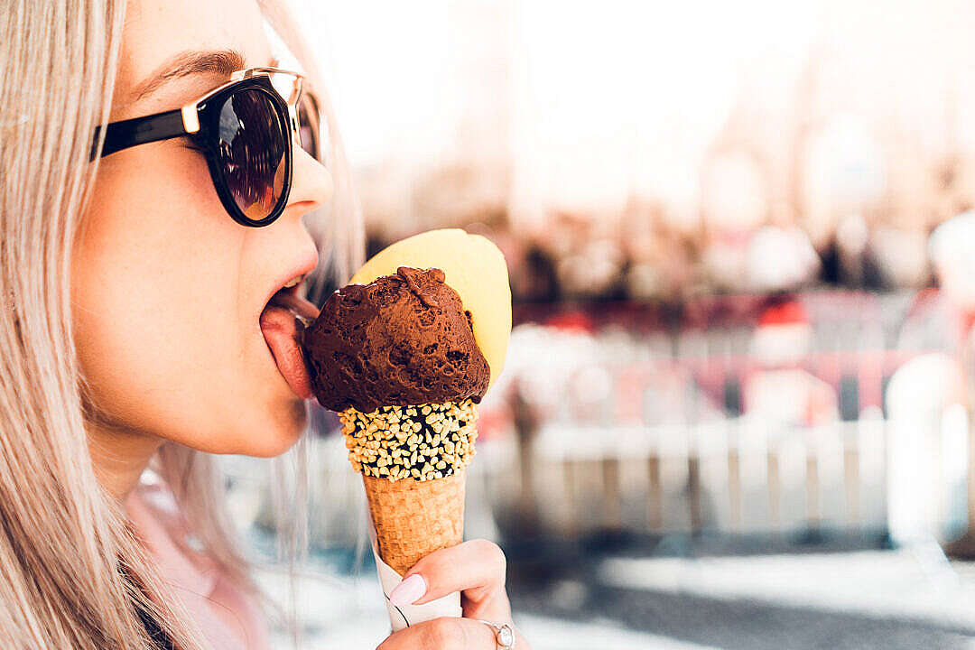Download Happy Girl Licking Chocolate Ice Cream in Summer FREE Stock Photo