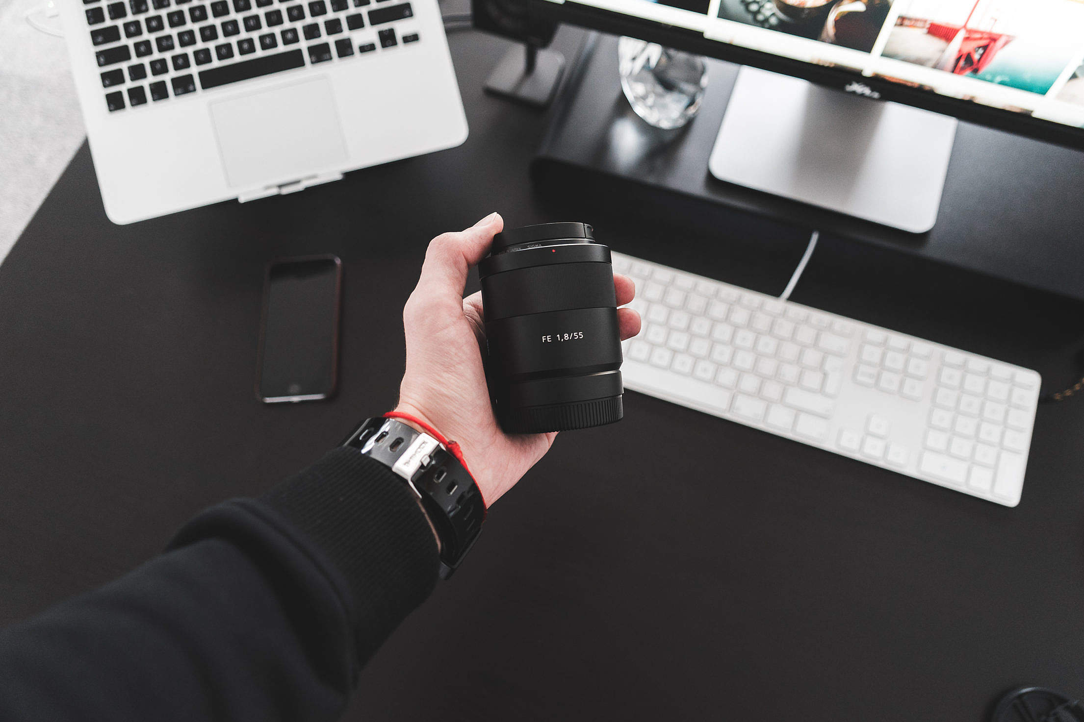 Holding Sony Zeiss Sonnar FE 55mm f/1.8 Lens in Hand #2 Free Stock Photo