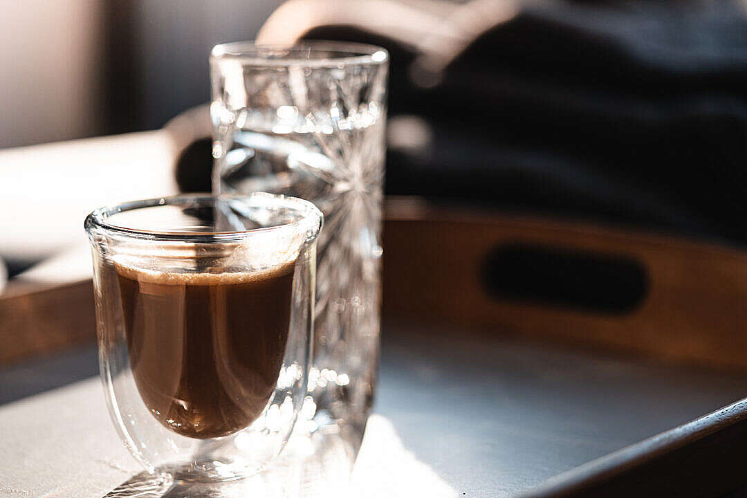 Homemade Lungo Coffee and a Glass of Water on a Tray