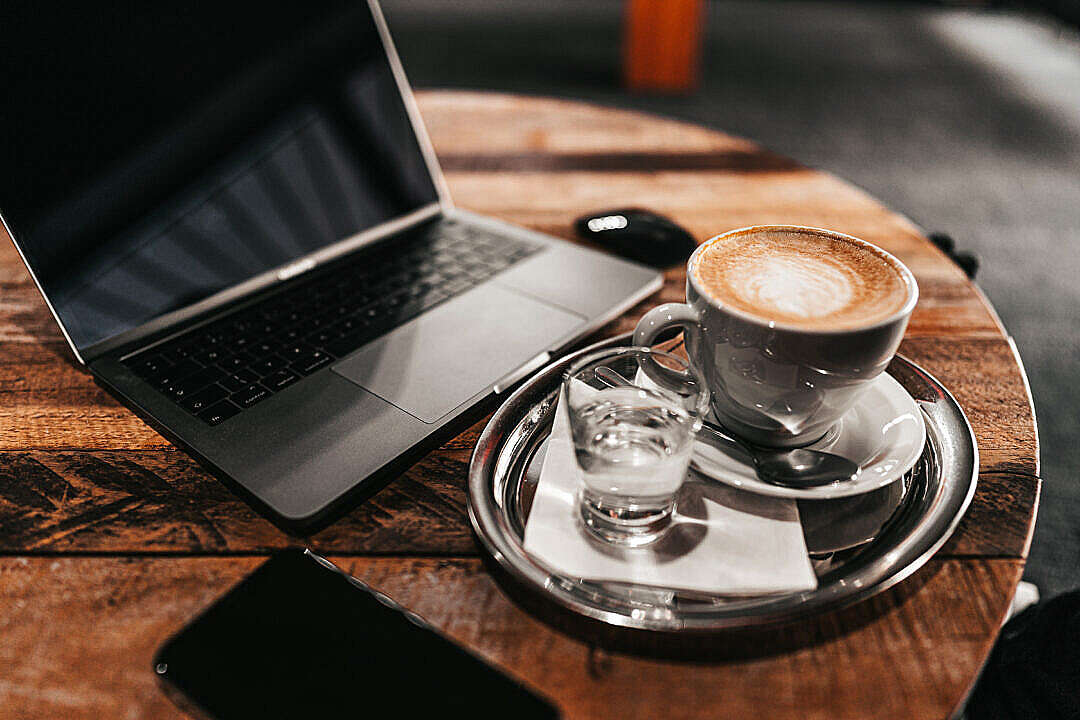 Laptop and Cappuccino on a Wooden Table