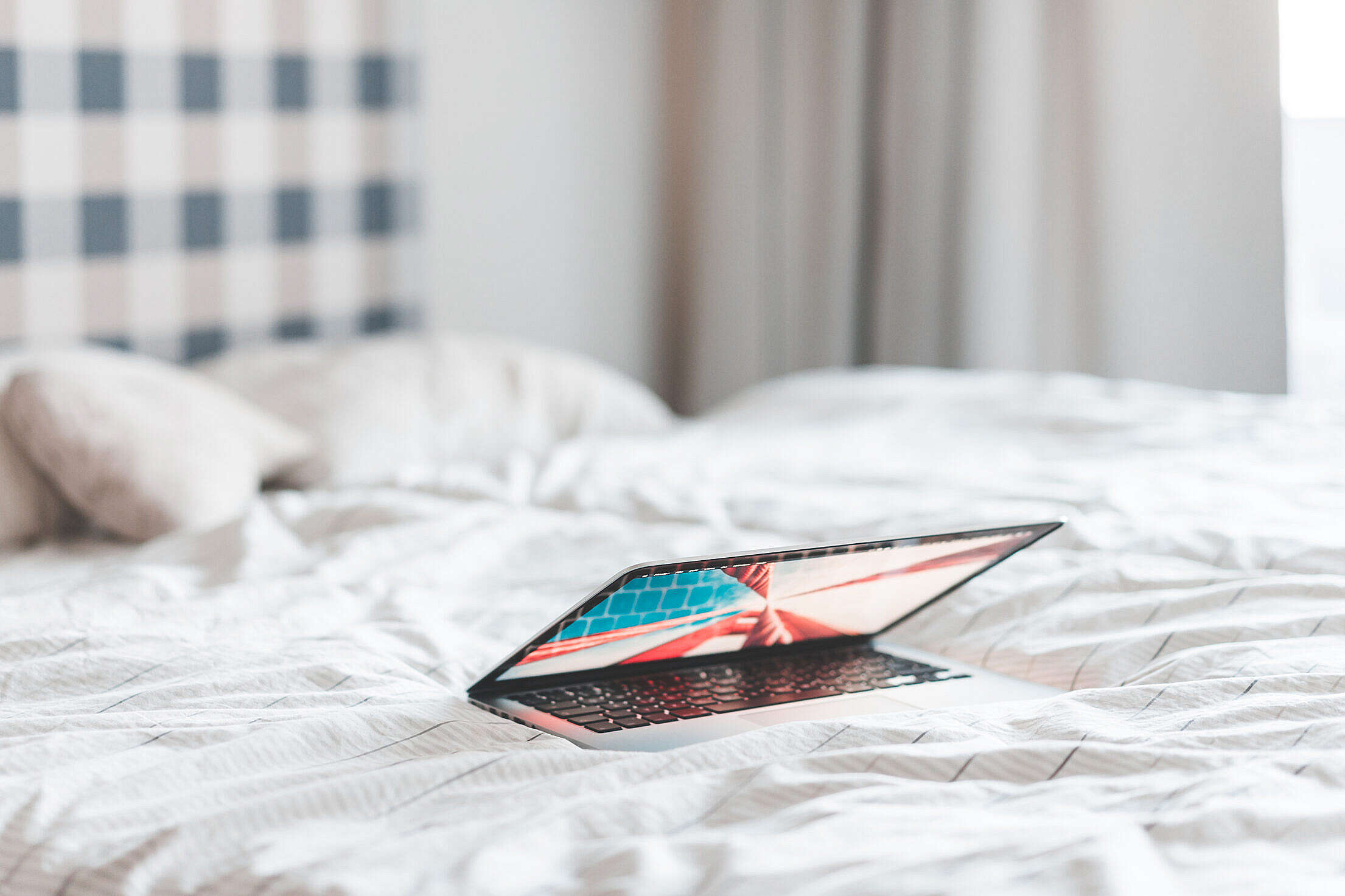 Laptop Lying in a Bed Free Stock Photo