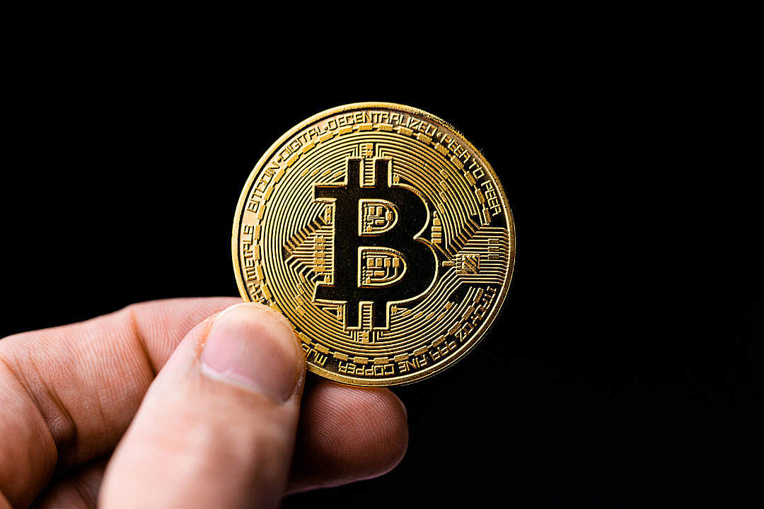 Man Holding a Bitcoin Coin