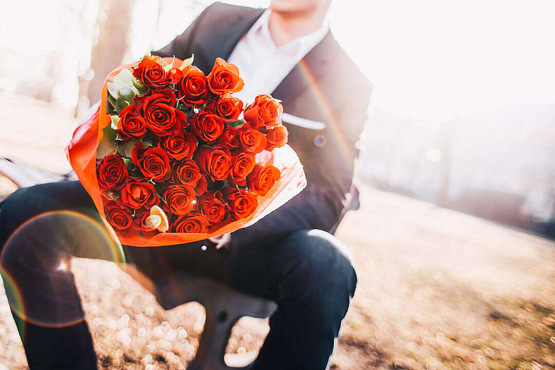 Man Holding a Bouquet of Red Roses