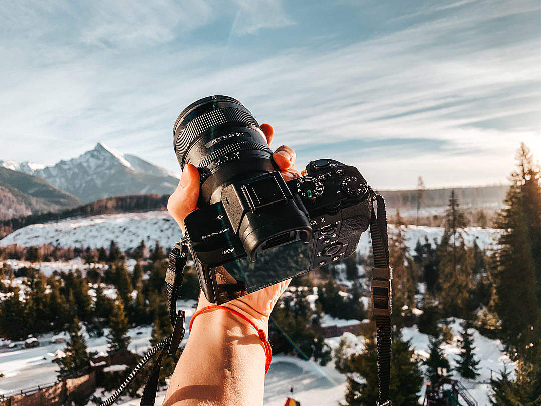 Man Holding a Camera in Mountains