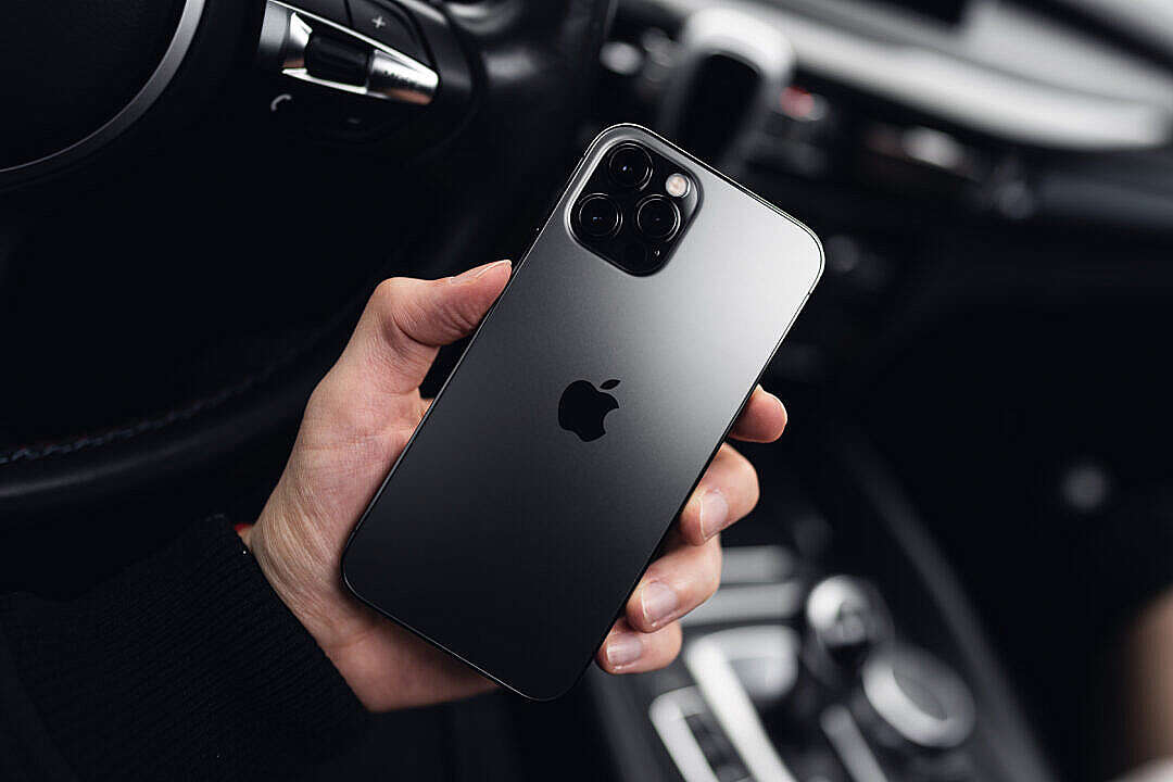 Man Holding a New iPhone 12 Pro in a Car