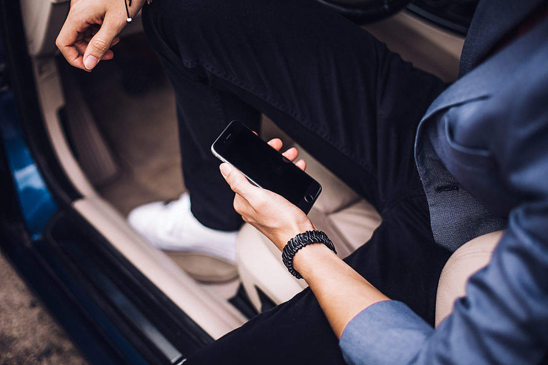 Man Holding iPhone in His Car