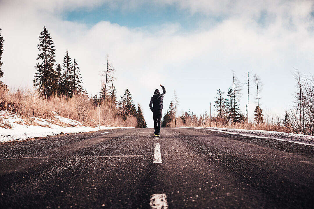 Man in a Winner Pose Walking on the Road
