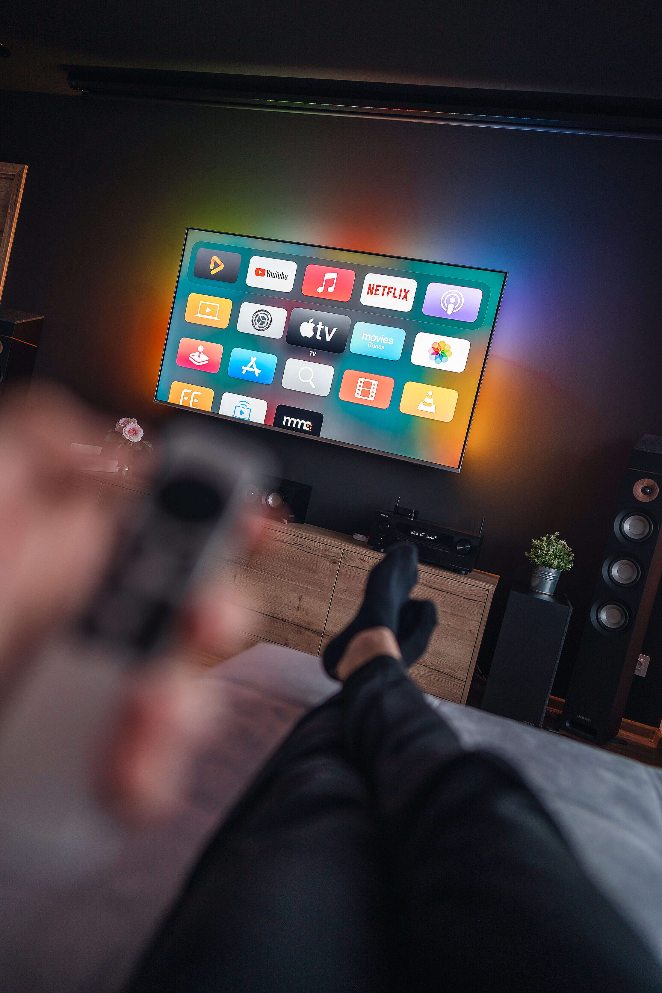 man-is-lying-on-a-sofa-and-watching-movies-on-apple-tv-free-stock-photo