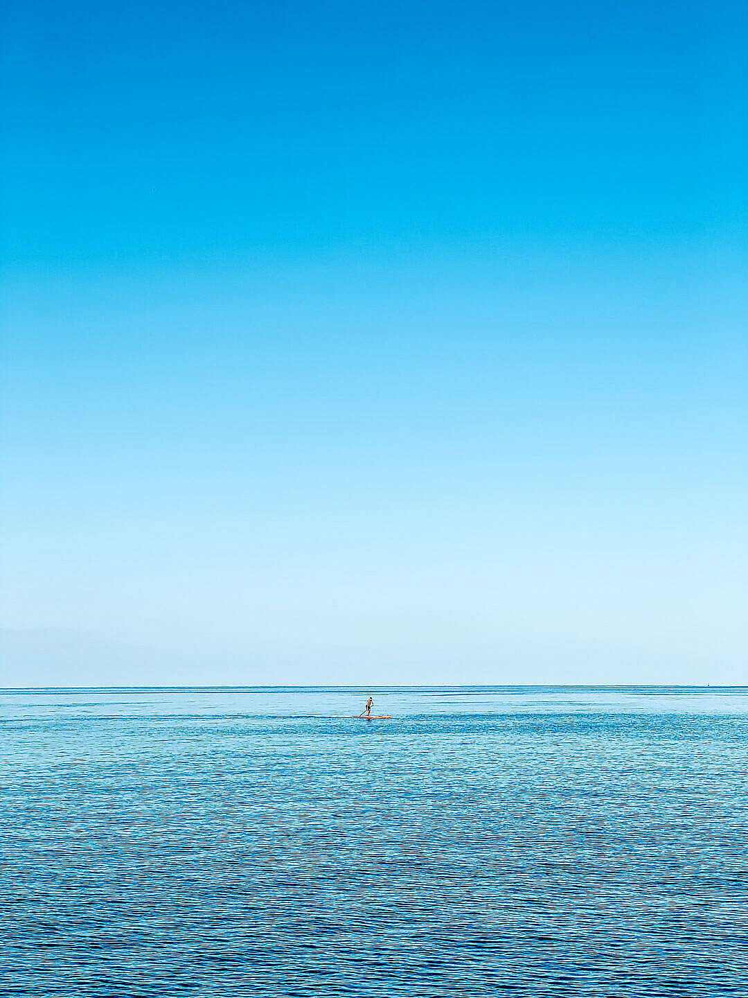 Man on a Paddleboard on the Open Sea