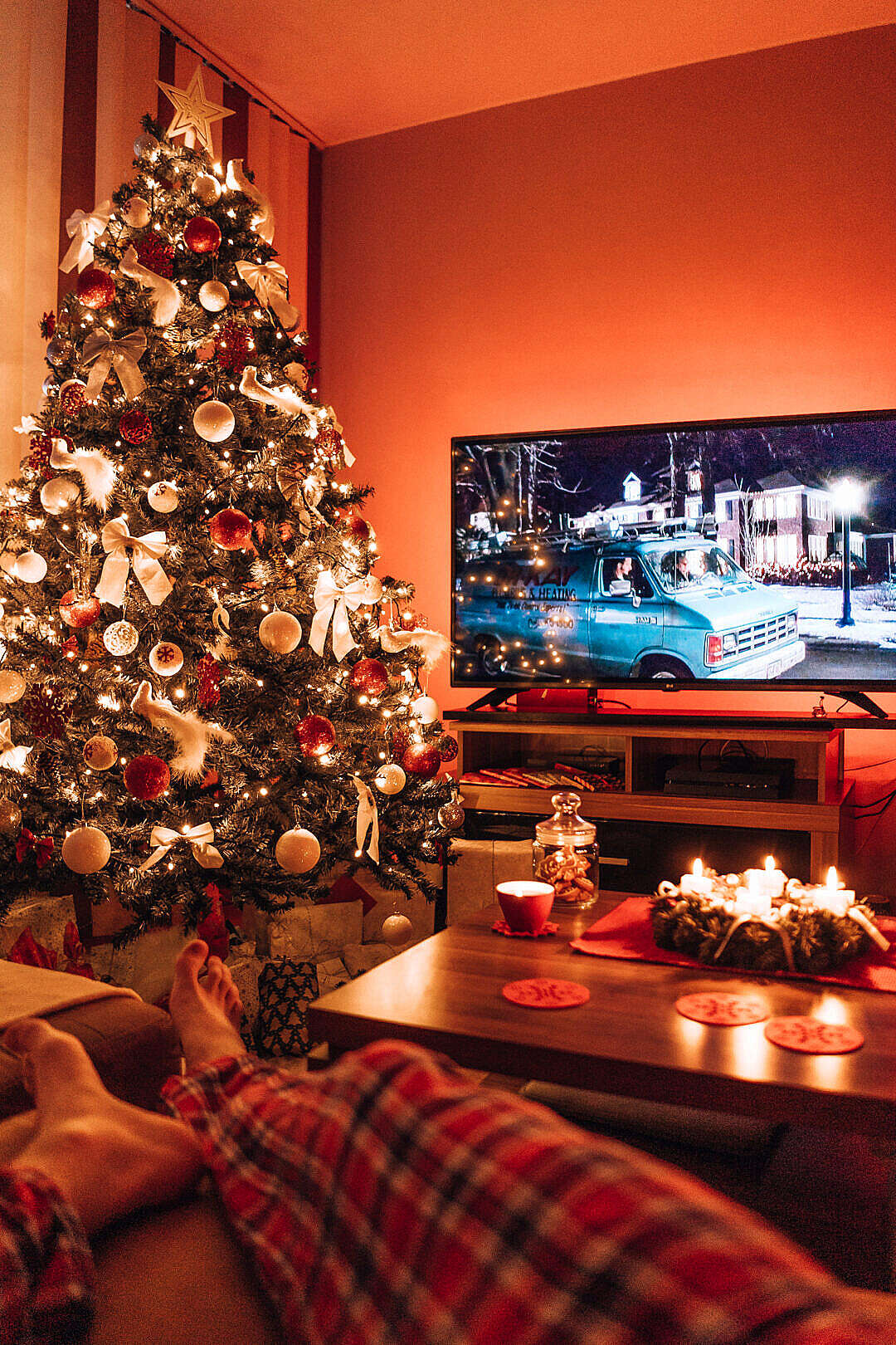 Download Man Relaxing in a Living Room and Watching a Christmas Movie in the Evening FREE Stock Photo