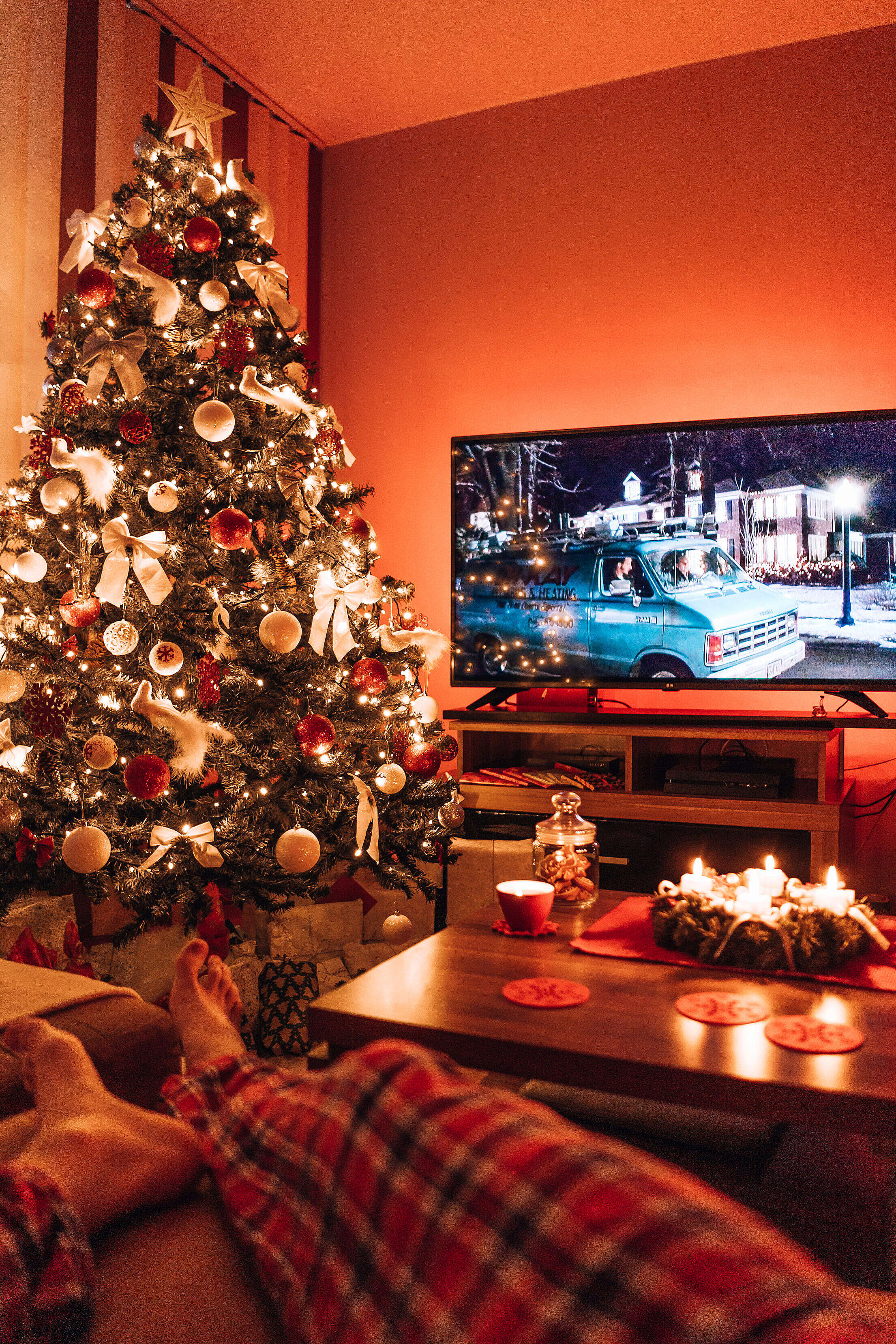 Man Relaxing In A Living Room And Watching A Christmas Movie In The 