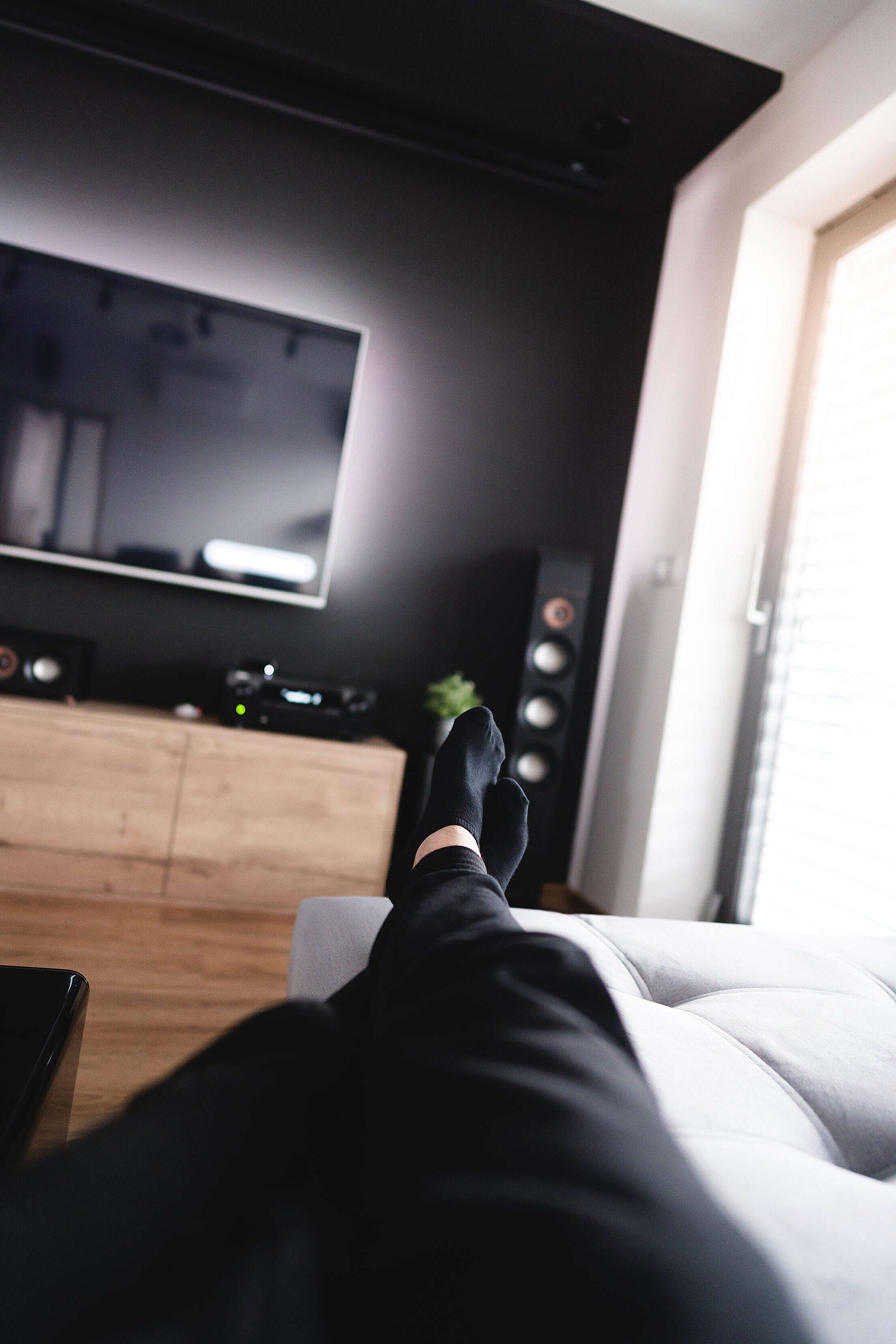 Man Relaxing on a Sofa in a Home Theater Living Room Free Stock Photo