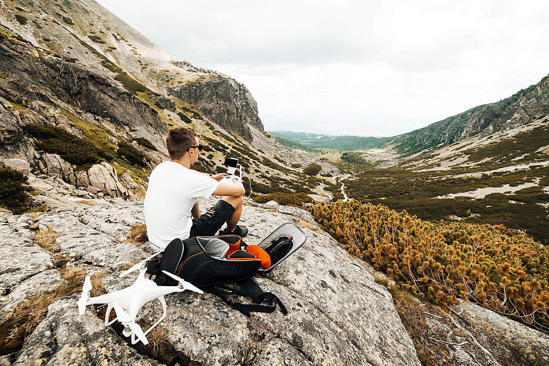 Man Setting Up a Drone for Aerial Photography in Mountains
