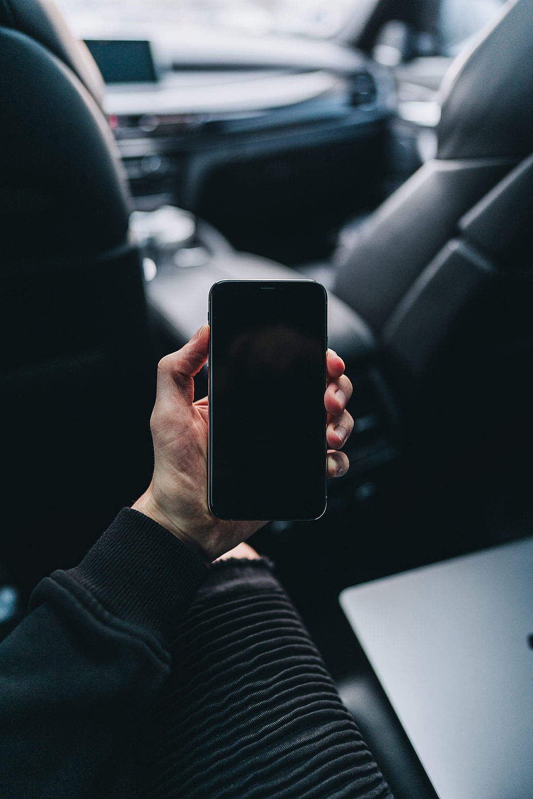 Download Man Sitting in a Car and Holding an iPhone FREE Stock Photo