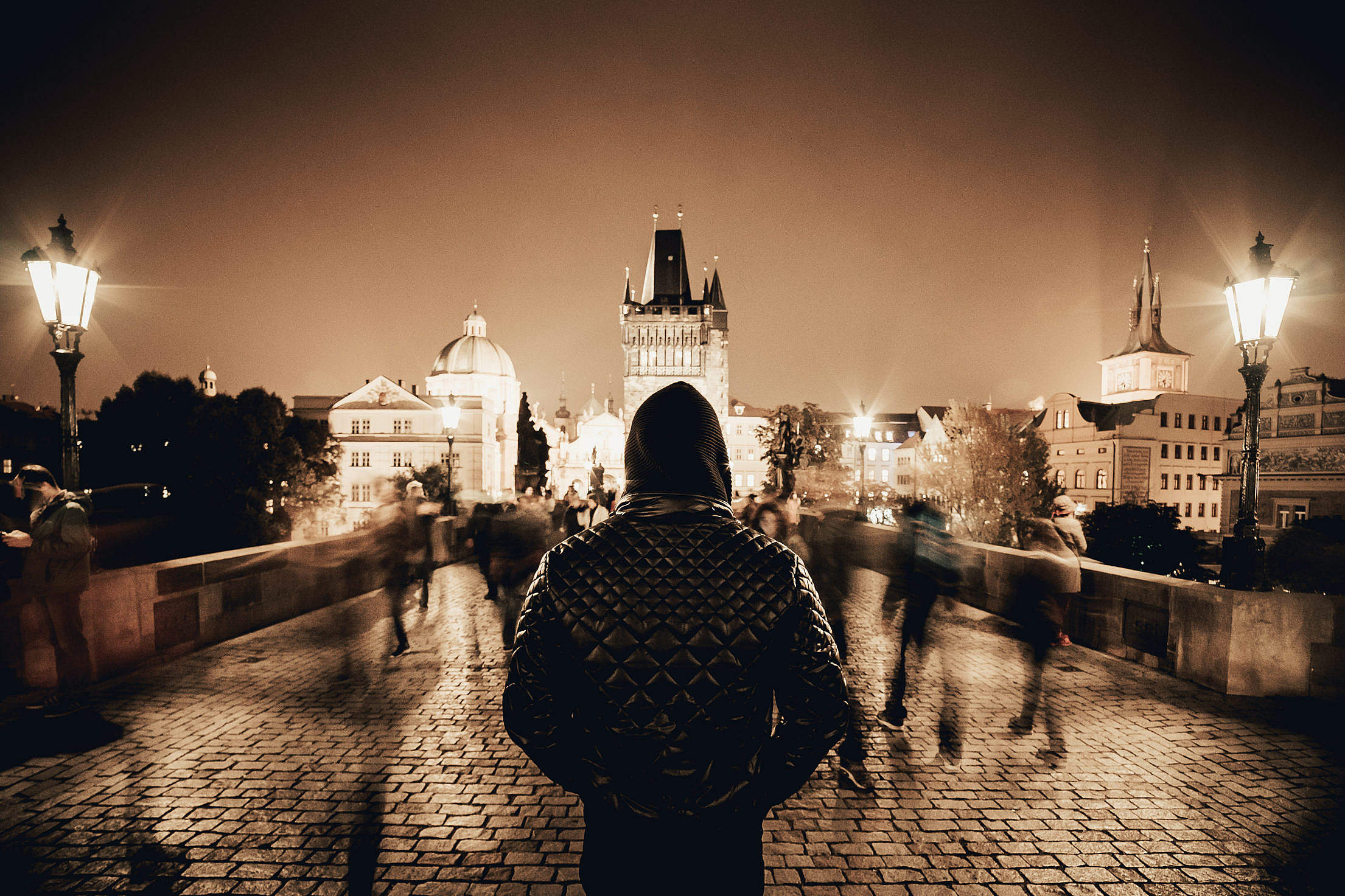 Man Standing on Prague’s Charles Bridge in Sepia Tone Free Stock Photo