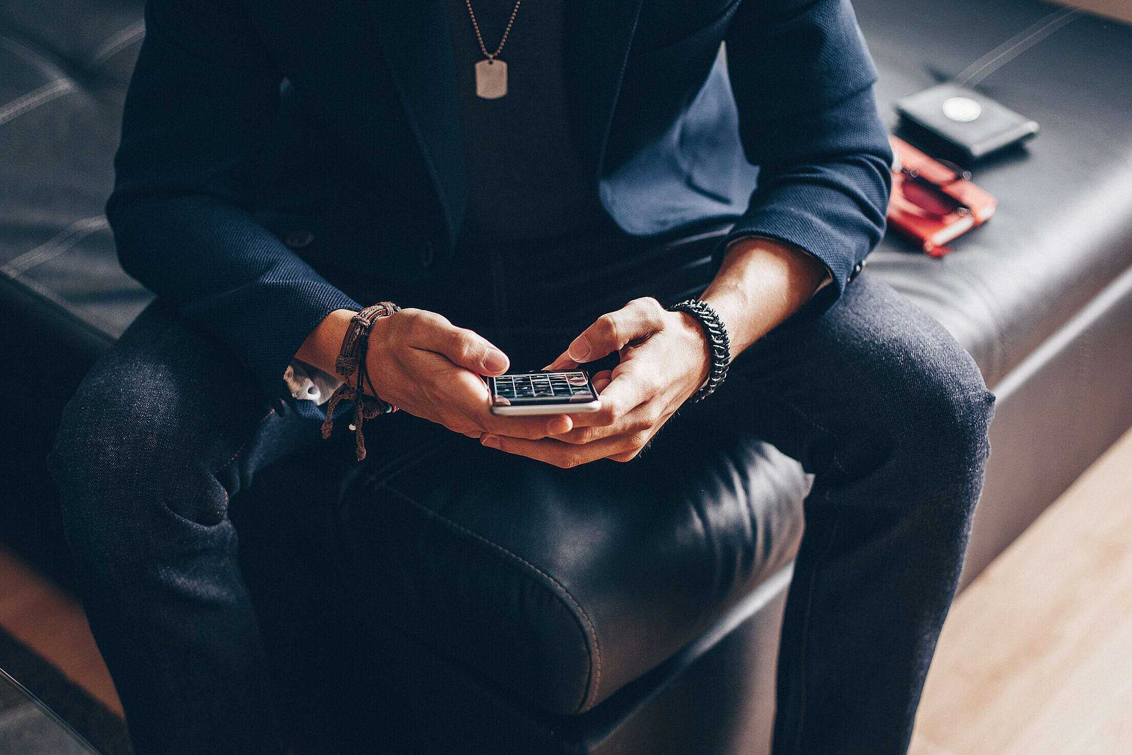Man Using his iPhone 6 on a Sofa Free Stock Photo