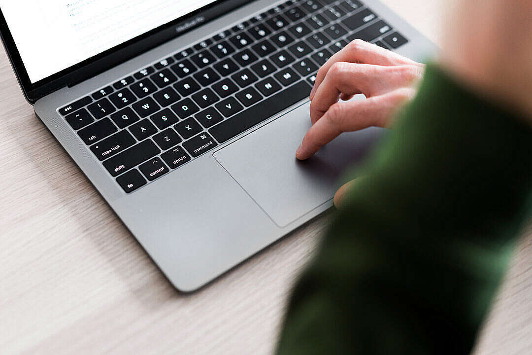 Man Using Touchpad on His Laptop