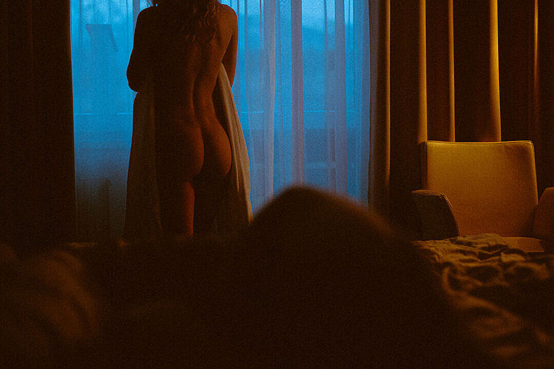Naked Woman Standing by Window in Dark Hotel Room in The Evening