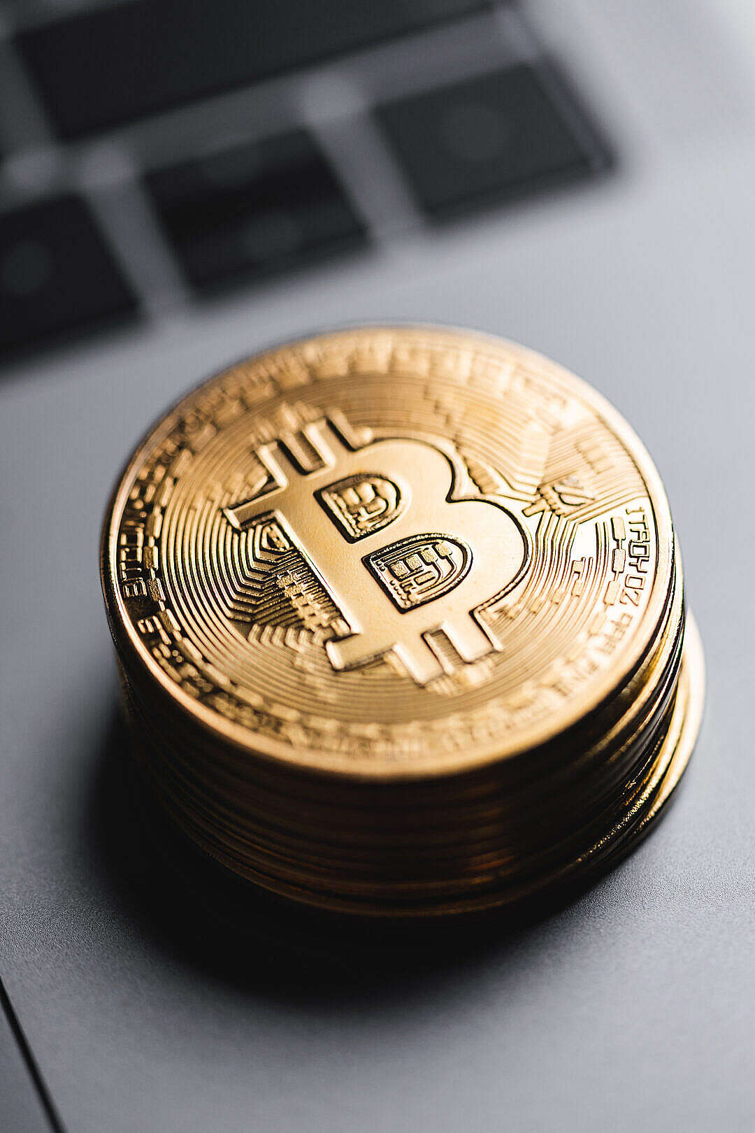 Download Pile of Bitcoins Lying on The Laptop Close Up FREE Stock Photo