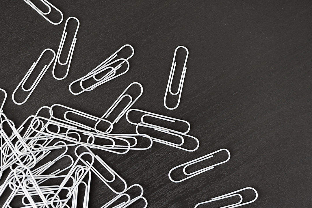 Download Pile of Silver Paper Clips on Black Desk FREE Stock Photo