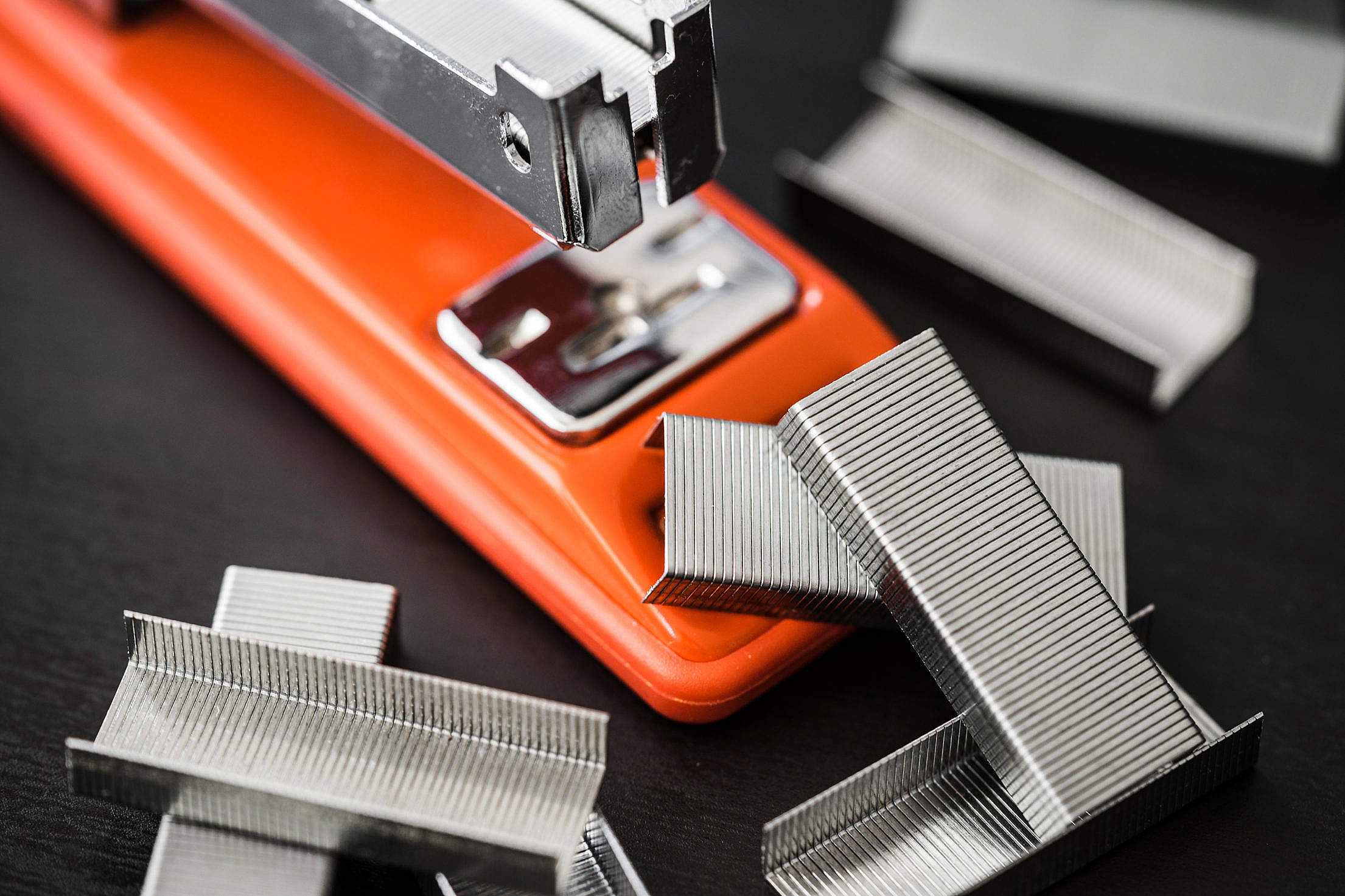 Red Office Stapler and Pile of Copper Office Staples Free Stock Photo