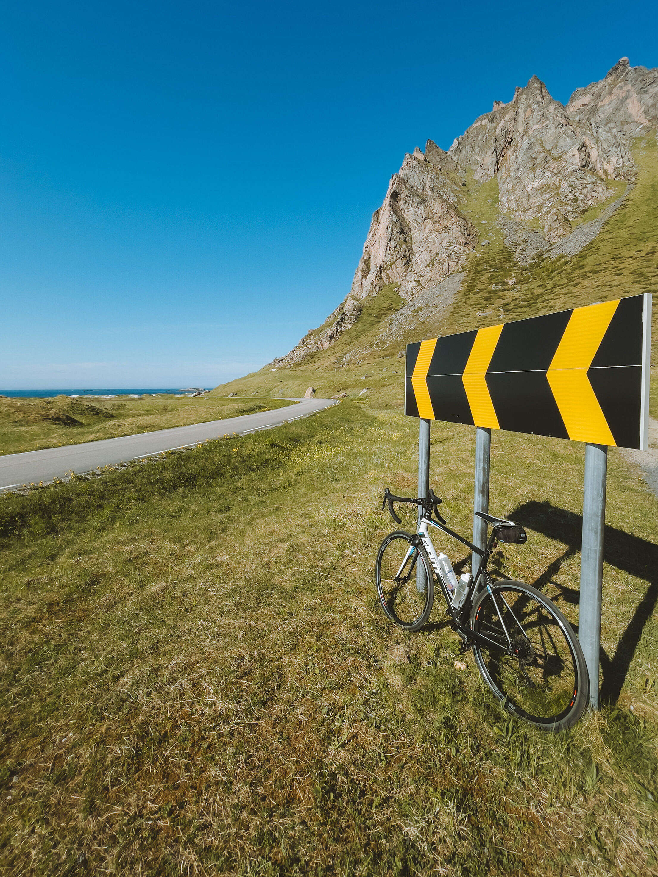 Road Bike and a Road Sign on a Coastal Road Free Stock Photo