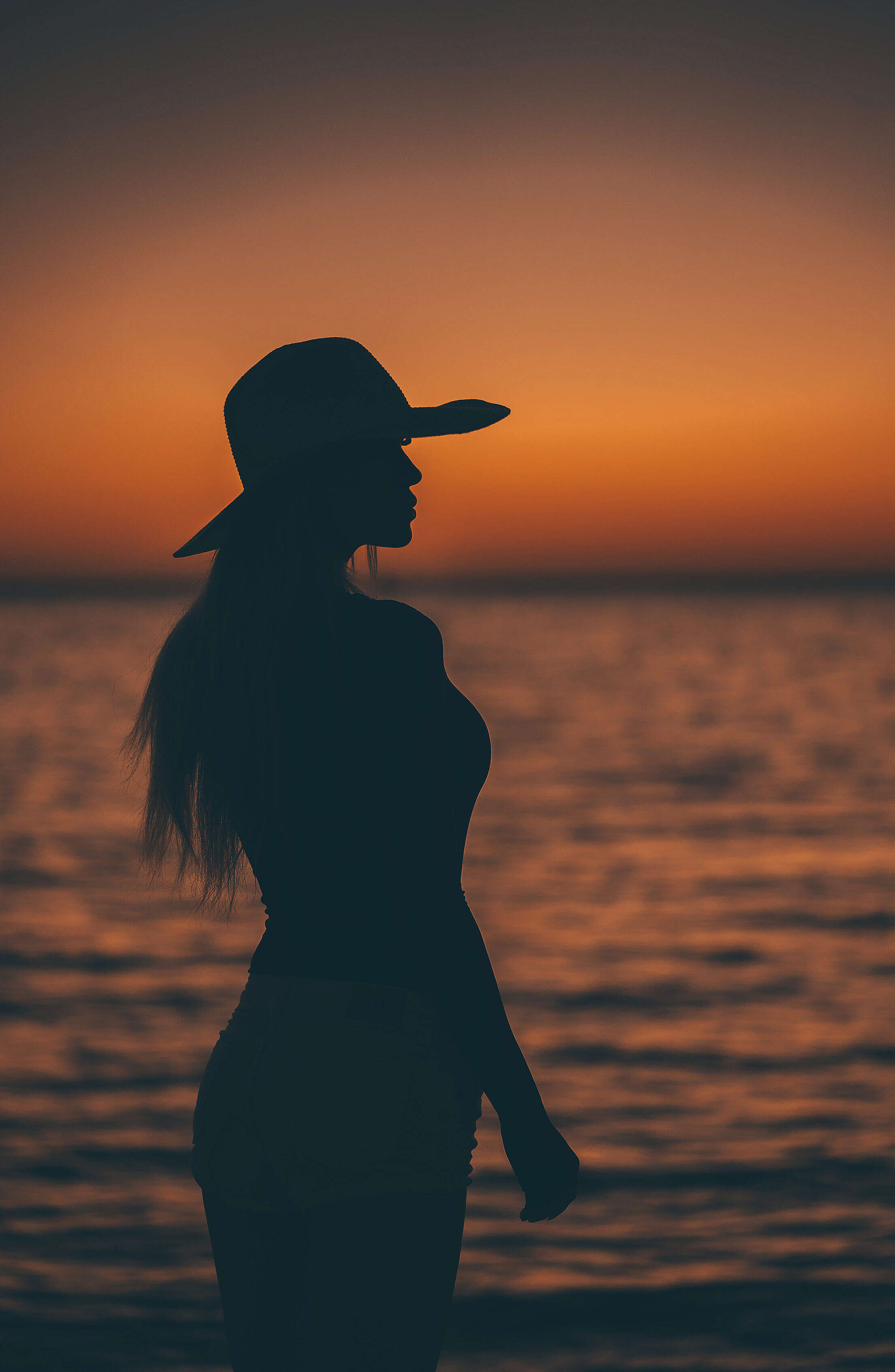 Silhouette of a Woman After Sunset by the Sea Free Stock Photo
