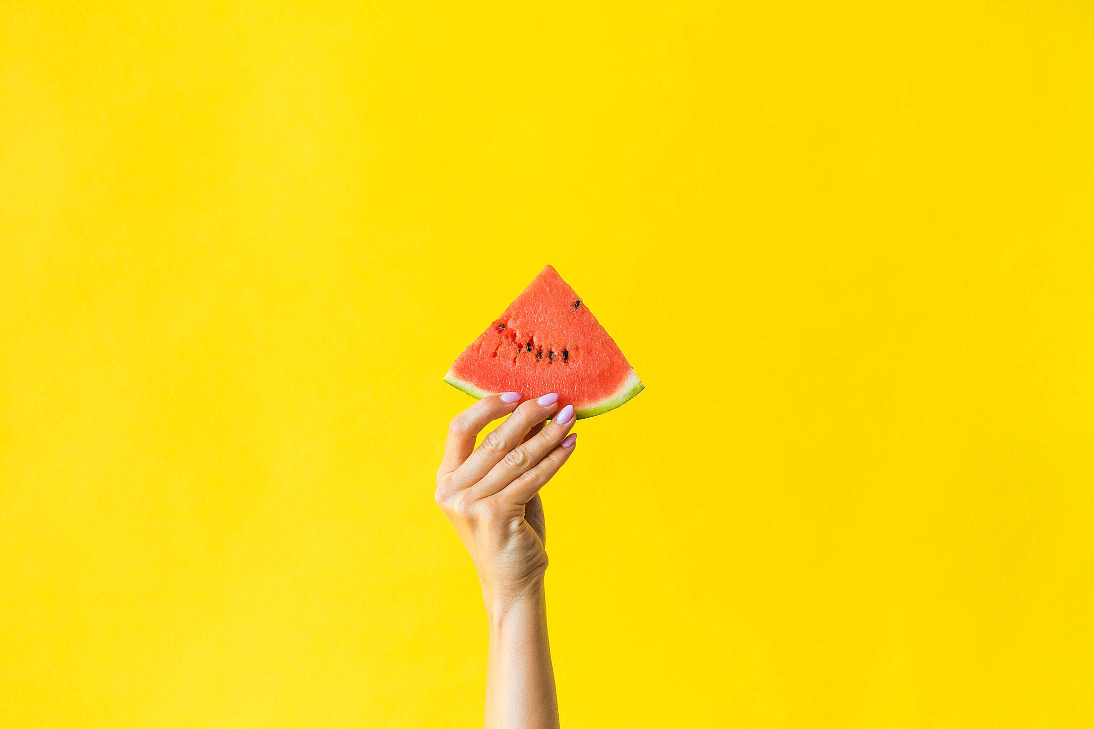 Slice of Watermelon in Woman Hand on Bright Yellow Background Free Stock Photo