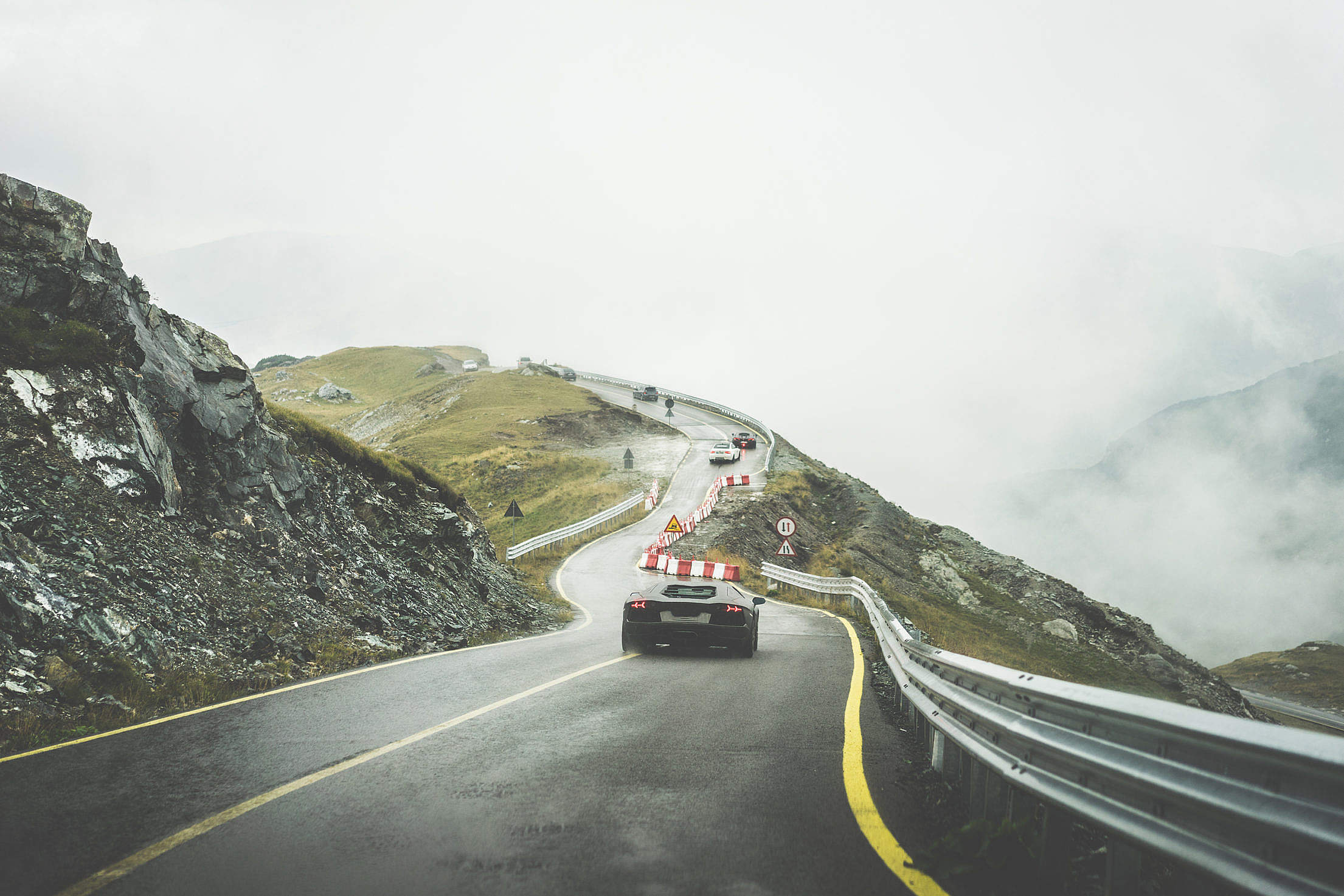 Sport Cars on Wet Mountain Road in Rainy Weather Free Stock Photo